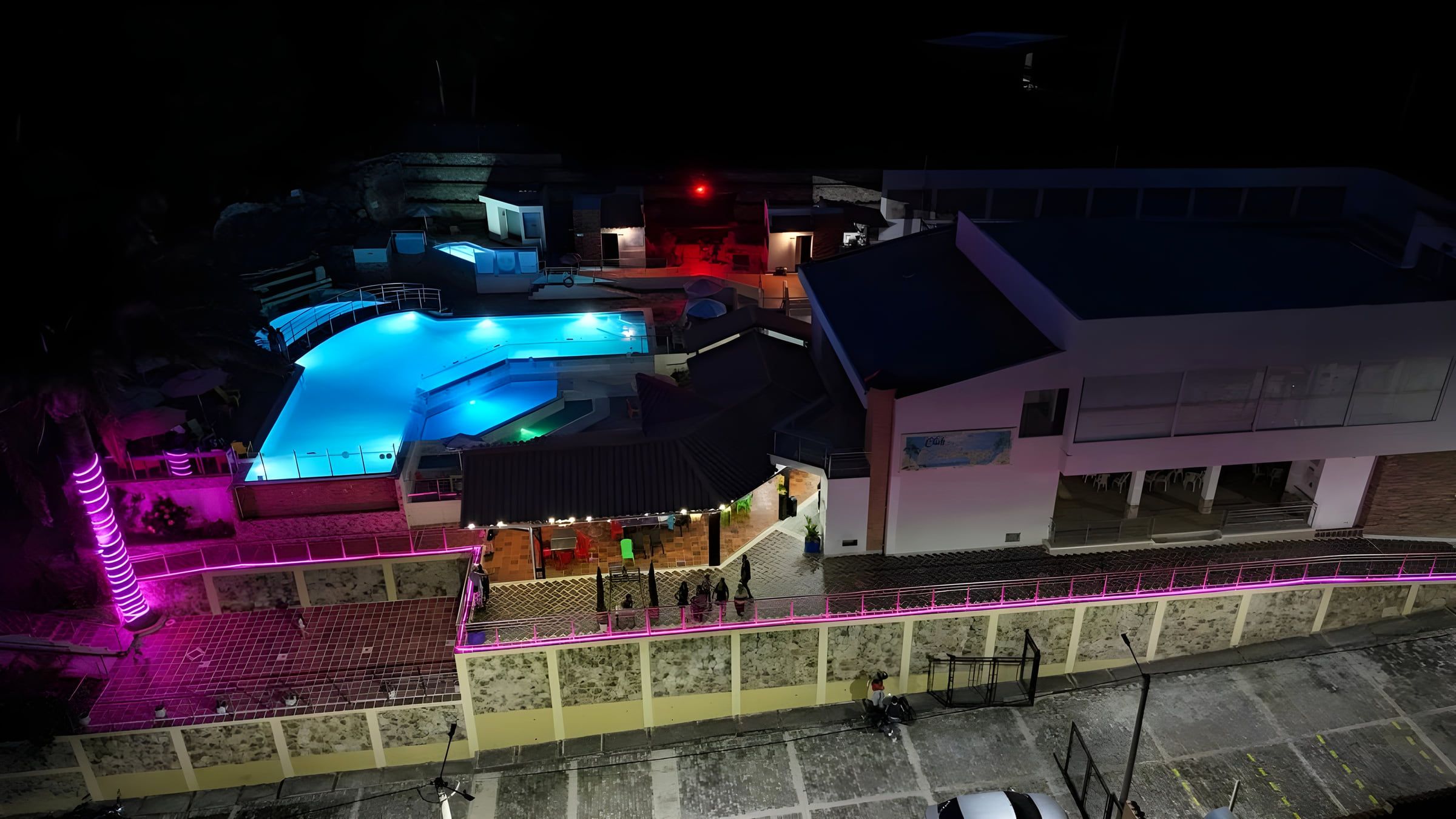 Panorámica nocturna del Club El Pedregal con la piscina iluminada, en Enciso